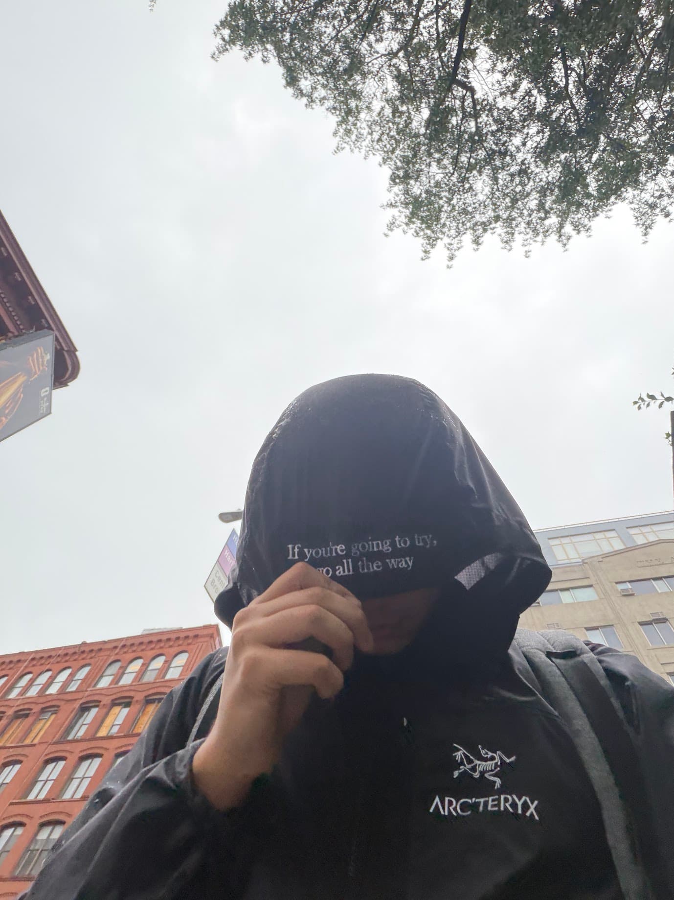 Shayaan wearing a black Arc'teryx jacket with the opening of the Charles Bukowski quote embroidered inside the hood